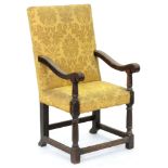 An oak armchair, the over-scrolled arms terminating in volutes on barrel supports, with conforming