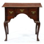 An oak lowboy, 19th c, with three cockbeaded drawers about the arched apron, on moulded cabriole