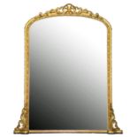 A Victorian giltwood and composition overmantle mirror, the arched frame with carved and moulded