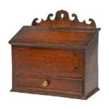 A George III wall hanging oak candle box with drawer, the wavy back plate pierced for suspension,