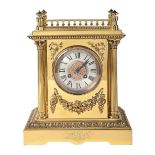 A French brass mantel clock, late 19th c, of pillar shape flanked by columns beneath stepped