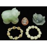 Two bracelets of carved jade beads, a jade carving of a pig, toad and a smaller relief, pig 92mm h