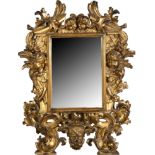 A North Italian giltwood mirror, 19th c, carved in high relief with the heads of putti and foliage