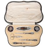 A George V silver inlaid tortoiseshell inset silver manicure set, of six pieces and scissors, by