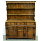 An oak dresser, with boarded rack, the front fitted with moulded drawers and panelled doors with