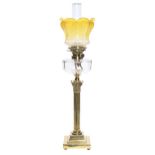 An Edwardian brass Corinthian column oil lamp, with faceted glass shade, brass burner and an