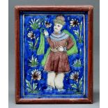 A Persian tile,  early 20th c, painted with a man flanked by flowers on a blue ground, 21 x 16cm,