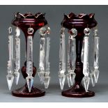 A pair of ruby glass lustres, late 19th c, with gilt rim and prismatic cut glass beads and pendants,