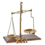 A Victorian brass beam scale, on mahogany base, 50cm h and a quantity of brass weights Some wear and