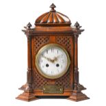 A Continental walnut mantel clock, c1900, the pillar shaped case with lobed top and finials, the