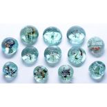 Twelve similar glass dump type paperweights, 19th c, 10cm and smaller Several with annealing flaws