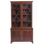 A mahogany bookcase, early 19th c, with stepped cornice and figured frieze, fitted with adjustable