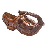 A Swiss musical carved walnut bottle cradle in the form of a clog, mid 20th c, 32cm l Good