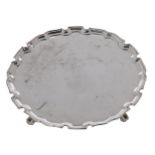 An Elizabeth II silver salver, on four volute feet, 25.5cm diam, by H H Plante, London 1955, 18ozs