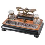 A Victorian walnut and ebonised inkstand incorporating brass postal balance, with pair of moulded