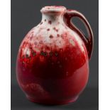 A Ruskin flambé ewer, 1933,  of onion form, the rich crimson red glaze over an ivory ground and