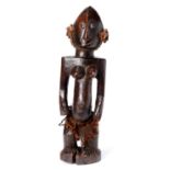 Tribal art. A Yoruba wood female figure, with fibre skirt and necklace, 47cm h Shrinkage crack in