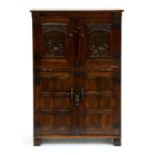 A carved oak cocktail cupboard,  with slide, 129cm h; 40 x 84cm Good condition