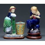 Two majolica figures of girls, late 19th c, one kneeling beside a basket, 25cm h, unmarked One