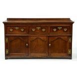 A George III oak dresser, early 19th c, fitted with three drawers above three ogee arch panelled
