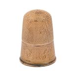 A gold thimble, c1900, engraved with initials on a band of chevrons, 22mm h, contemporary plush