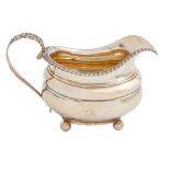 A George IV silver cream jug, with gadrooned rim, on ball feet, 10cm,h by George Burrows, London