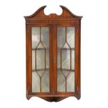 A mahogany hanging corner cabinet, 20th c, with swan neck pediment, 105cm h; 30 x 60cm Tiny veneer