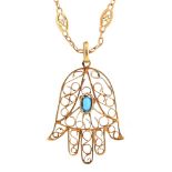 A gold filigree flower shaped pendant, 20th c, set with a central turquoise, 28mm, unmarked, on gold