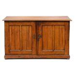A Victorian oak cupboard, the oblong top with ovolo lip, enclosed by a pair of panelled doors,