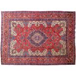 A red ground rug, 230 x 328cm Localised wear and slightly soiled from long term storage