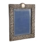 An Edwardian silver photograph frame, the die stamped mount with C-scrolls and trellis, 28cm h, by