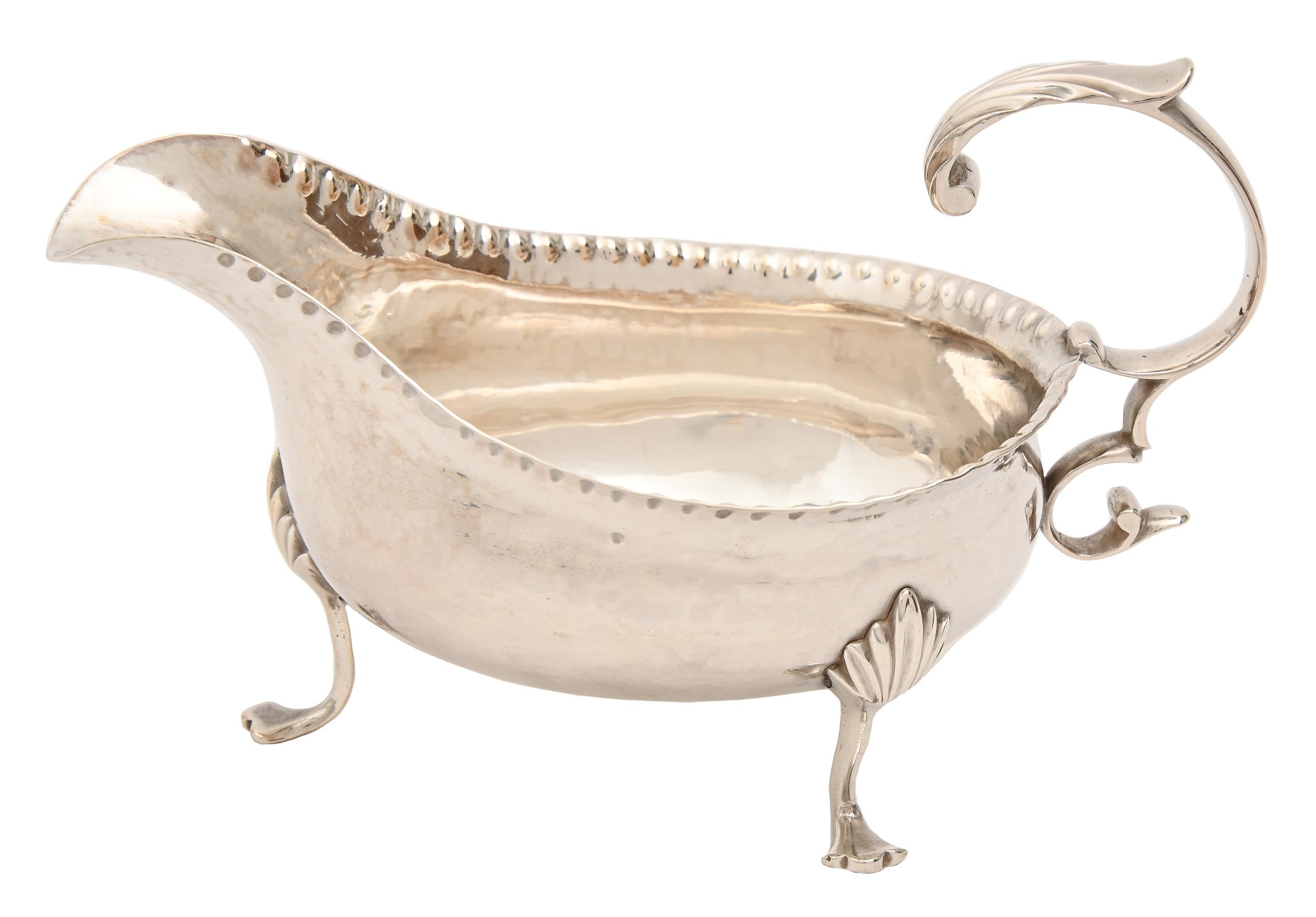 A George III silver sauceboat, with flying scroll handle, on three hoof feet, 14cm l, underside