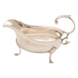 A George III silver sauceboat, with flying scroll handle, on three hoof feet, 14cm l, underside