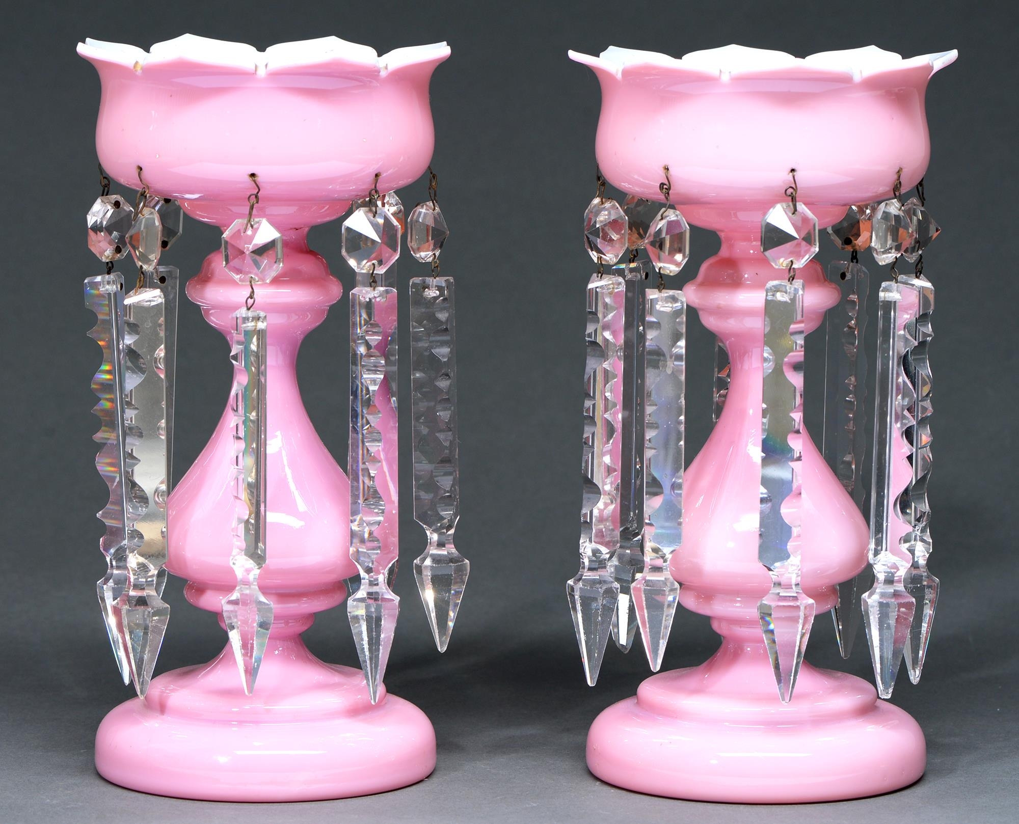 A pair of Victorian pink cased white glass lustres, with baluster stem and hung with prismatic cut