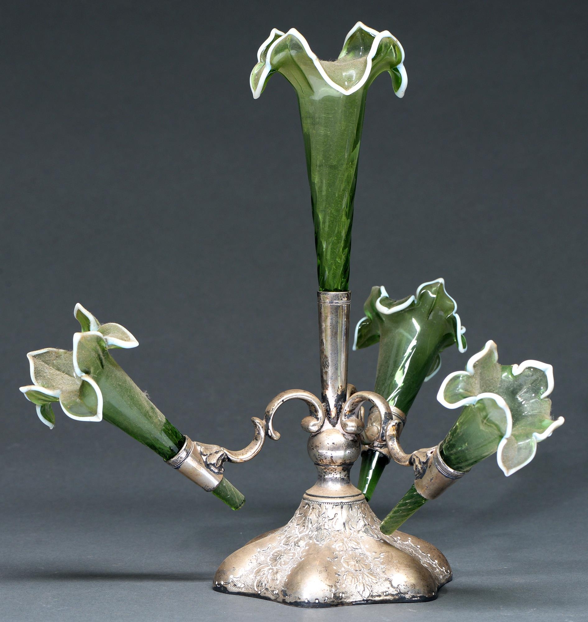A Victorian EPNS flower stand, the four wrythen fluted green glass trumpet vases with white rim,