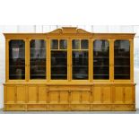 An unusually large Victorian scumbled breakfront bookcase, the central pediment with tablet and