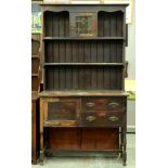 An Edwardian oak dresser, the panelled rack with central cupboard with leaded glass door, 216cm h;