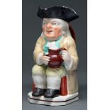 A Staffordshire Toby jug, c1820,  the seated toper holding a foaming jug of ale, wearing a light