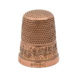 A 9ct gold thimble, with floral border, part marked London 1921, in contemporary marbled green