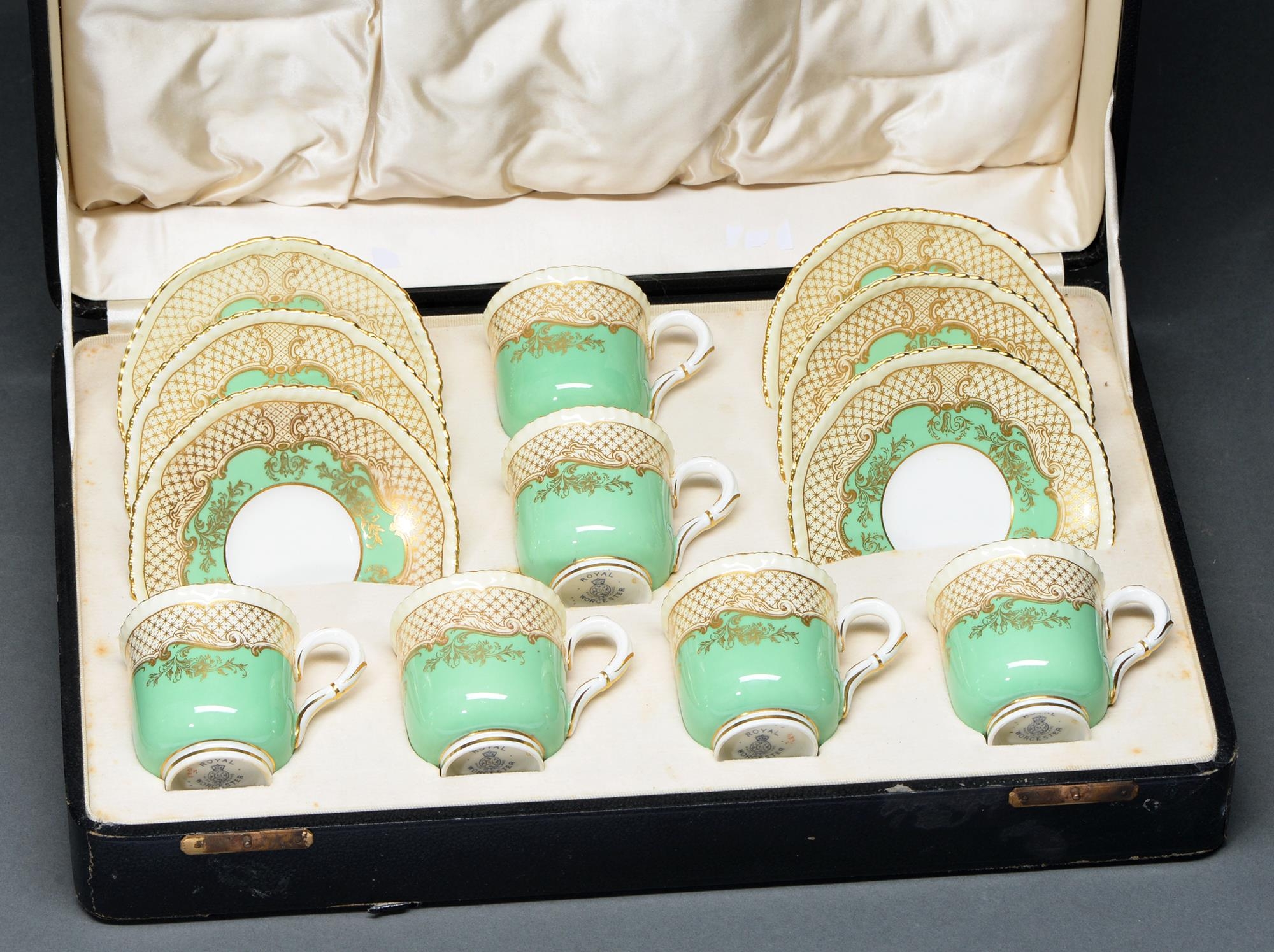 A set of six Royal Worcester apple green ground coffee cups and saucers, 1936, with gilt trellis