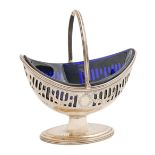 A George V pierced and engraved silver sugar basket, with reeded handle and rims, blue glass