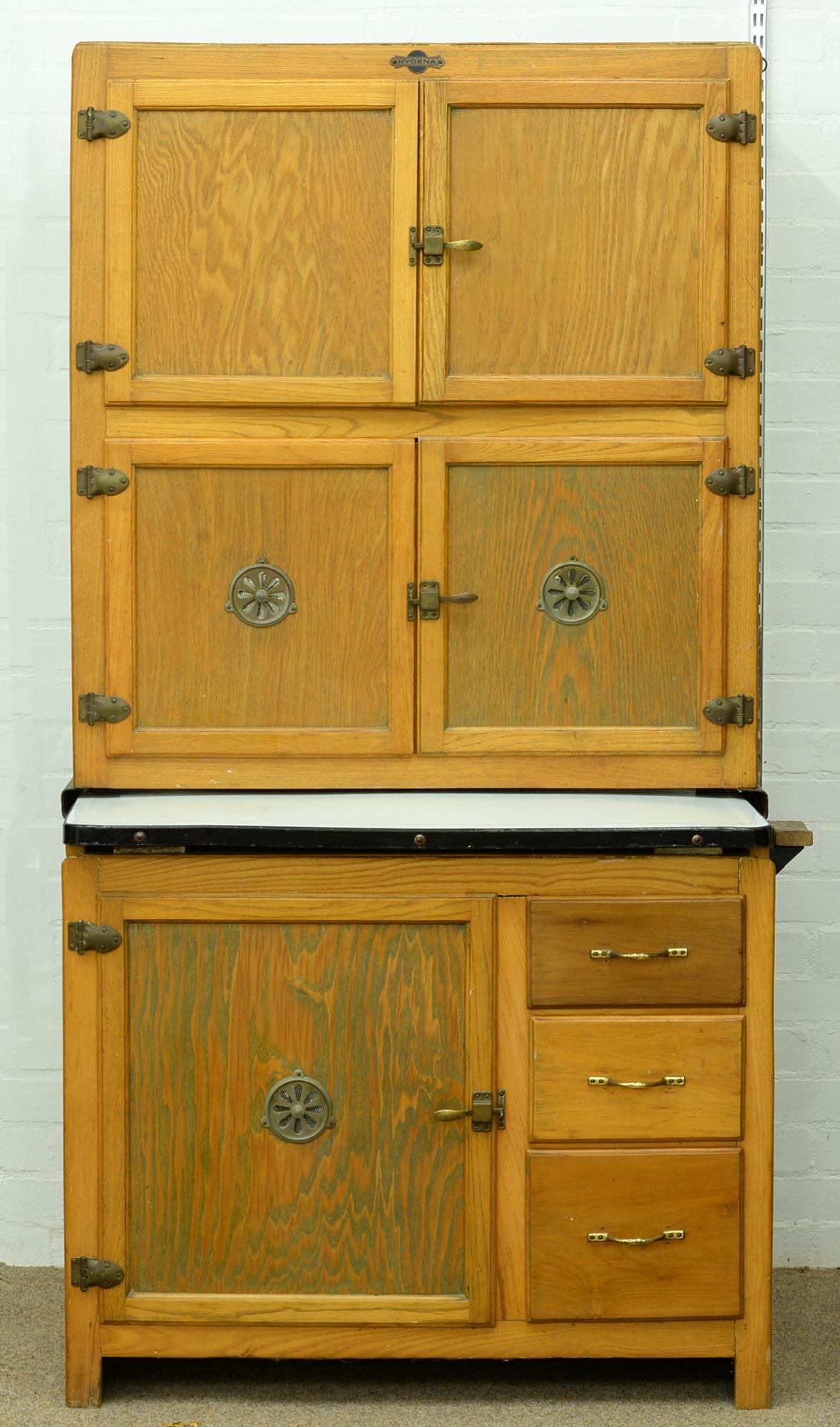 An early 20th c Hygena kitchen cupboard, with sliding enamelled work surface, the fitted interior