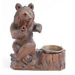 A Swiss anthropomorphic limewood  ashtray in the form of a bear smoking a pipe, c1900, 23cm h Good