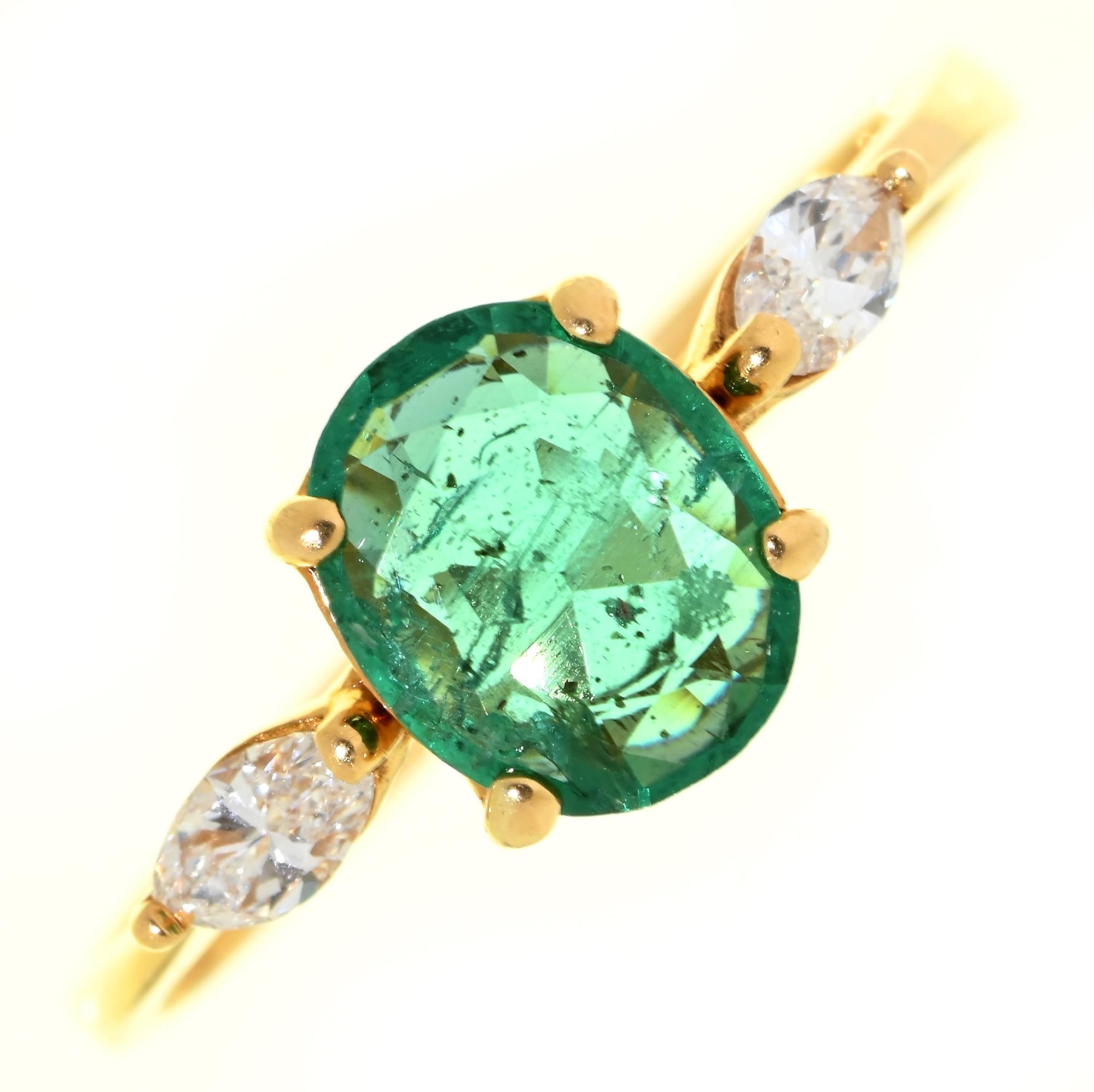 An emerald and diamond ring, the larger oval emerald flanked by navette diamonds, in gold, unmarked,