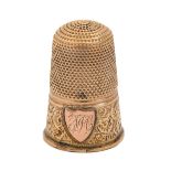 A gold thimble, late 19th c, engraved with initials on an applied shield, 23mm h, 3g Good condition