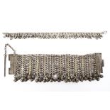 A late 19th century Omani white metal chain link bracelet with hanging bell decoration, 23cm long,