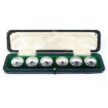 A cased set of six circular gentleman's sterling silver buttons with chased decoration