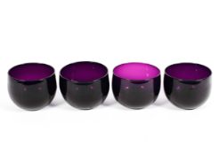 Four 19th century amethyst tinted glass finger-bowls,