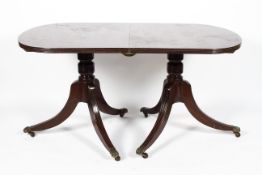 A Regency style twin pillar mahogany dining table,