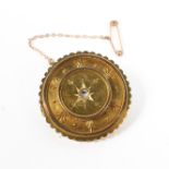 A yellow metal Etruscan style wheel brooch set with central rose cut diamond